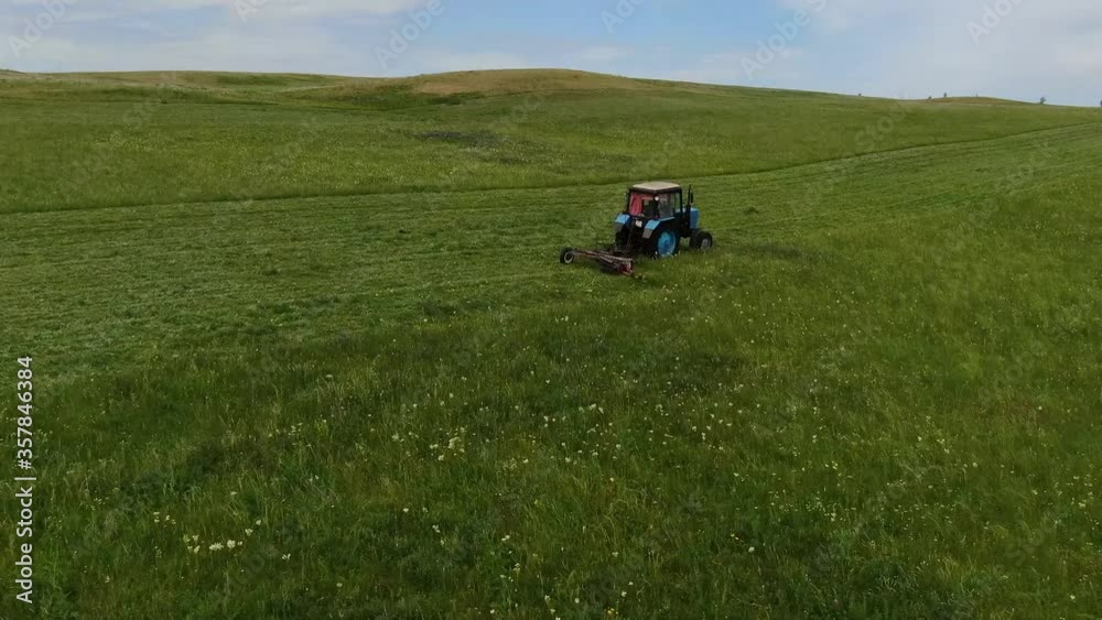 the view from the top. The tractor in the field to mow the grass. the view from the top. The tractor in the field to mow the grass.