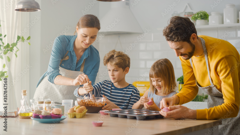 In the Kitchen: Family of Four Cooking Muffins Together. Mother and Daughter Mixing Flour and Water to Create Dough for Cupcakes, Father, Son Preparing Paper Lines for Pans. Children Helping Parents In the Kitchen: Family of Four Cooking Muffins Together. Mother and Daughter Mixing Flour and Water to Create Dough for Cupcakes, Father, Son Preparing Paper Lines for Pans. Children Helping Parents
