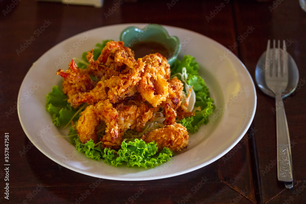 Deep fried thai squid rings on the plate with salad Deep fried thai squid rings on the plate with salad