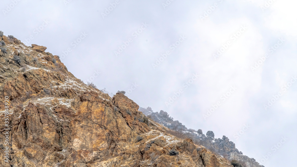 Panorama Snow dusted terrain of the rocky Prvo Canyon in Utah with cloudy sky background