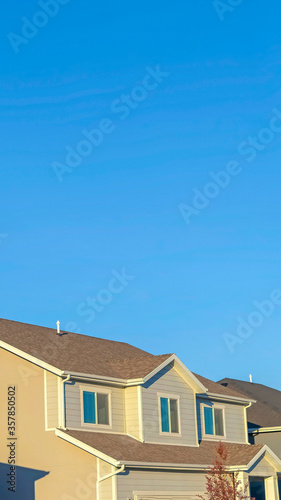 Vertical Homes with horizontal wall sidings and front gable roofs againts clear blue sky