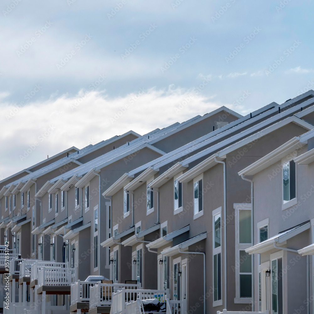 Square crop Townhomes in South Jordan Utah against Wasatch Mountains and cloudy sky Square crop Townhomes in South Jordan Utah against Wasatch Mountains and cloudy sky