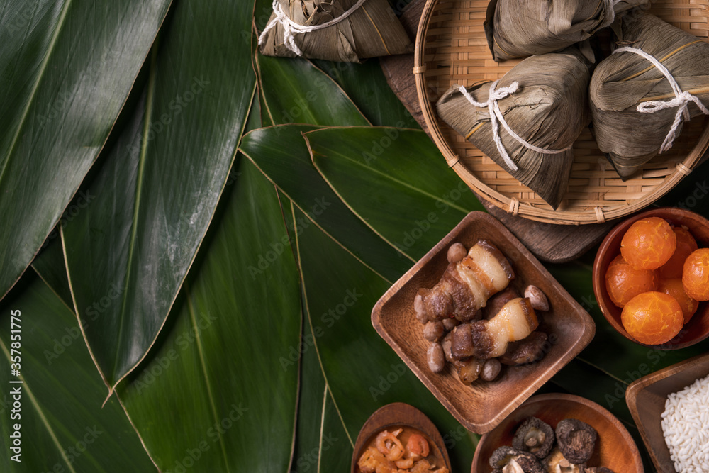 Rice dumpling, zongzi - Traditional Chinese food on green leaf background of Dragon Boat Festival, Duanwu Festival, top view, flat lay design concept.