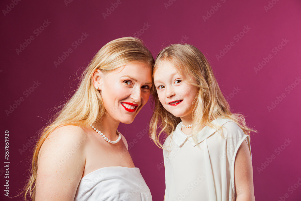 Portrait of mother and daughter isolated on purple background