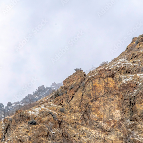 Square frame Snow dusted terrain of the rocky Prvo Canyon in Utah with cloudy sky background