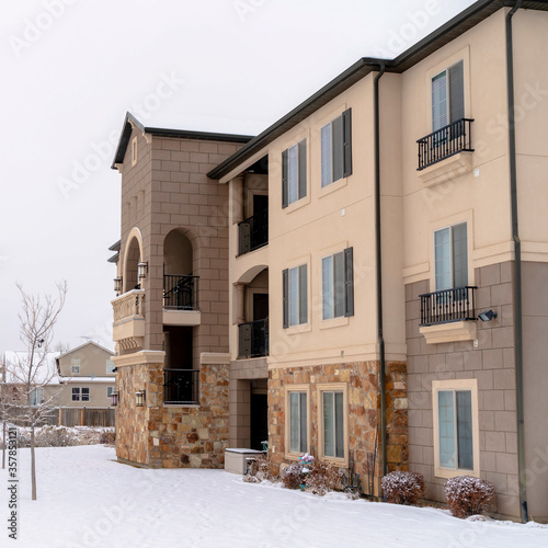 Square frame Apartments and houses against snow covered landscape and cloudy sky in winter