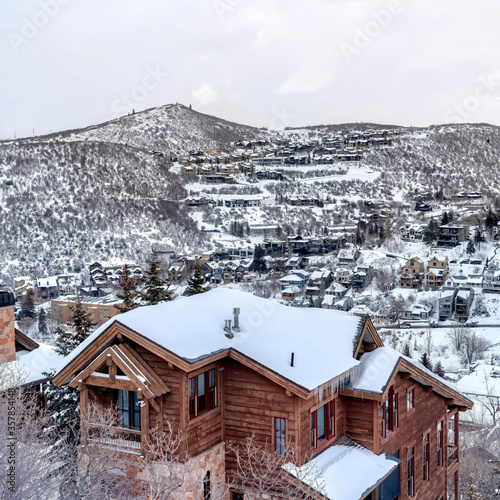 Square Home with snowy roof and wooden walls at the hill of Park City Utah in winter