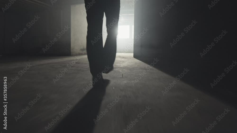 4K_Mann läuft vom Dunklen ins Licht_Detail auf Füße_Tracking