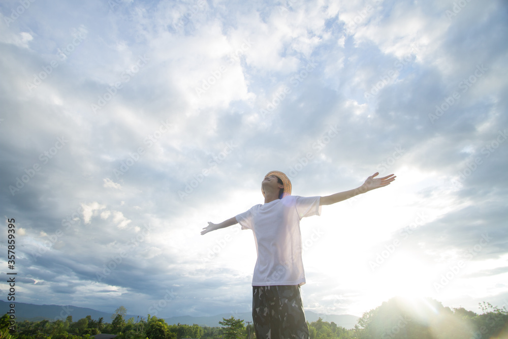 Happy Teen asian men looking to sky with smiling face with landscape of nature and sunset background Happy Teen asian men looking to sky with smiling face with landscape of nature and sunset background