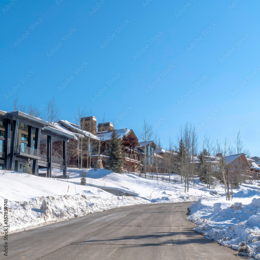 Square crop Road and homes on a luxury neighborhood in snowy Park City Utah in winter