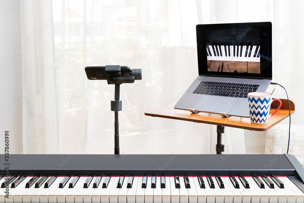 Online piano lessosn setup with a laptop, a piano keyboard and a smartphone  on a gimbal as camera. Home environment.. Stock Photo | Adobe Stock