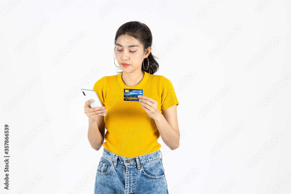 Attractive young Asian woman holding mobile smart phone and credit card on white isolated background. Shopping online concept. Attractive young Asian woman holding mobile smart phone and credit card on white isolated background. Shopping online concept.