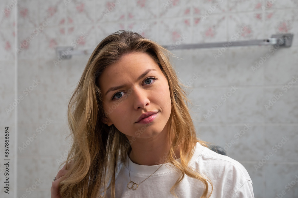 Portrait of Young Blond Woman in Bathroom Looking at Camera Portrait of Young Blond Woman in Bathroom Looking at Camera