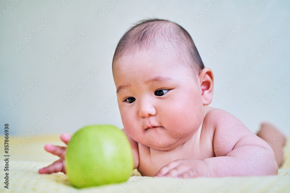 funny Asian kid and green Apple. healthy food for babies funny Asian kid and green Apple. healthy food for babies