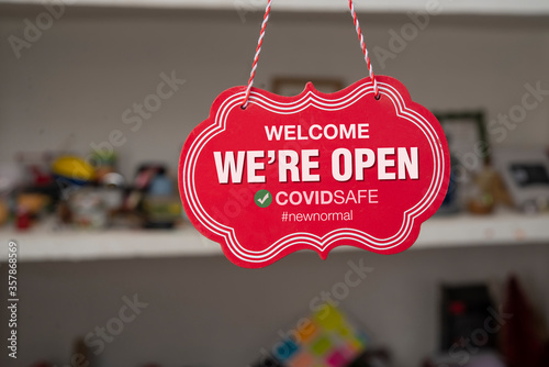 Welcome we are open sign in front of a shop after covid-19 pandemic  photo