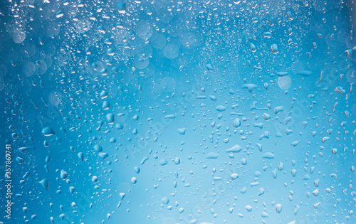 Blue water drops background. Blue water drops on a boat glass background. Water drops on boat glass blue bokeh background.
