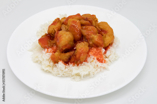 Sweet and Sour Chicken on White Rice on top of a White Plate