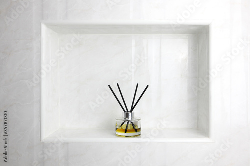 luxury glass aroma scent reed diffuser bottle is used as air freshener in the nice white toilet bahtroom to creat relax , cozy and clean ambient