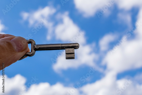 Key in hand with the sky as blurred background. success and achievement. photo