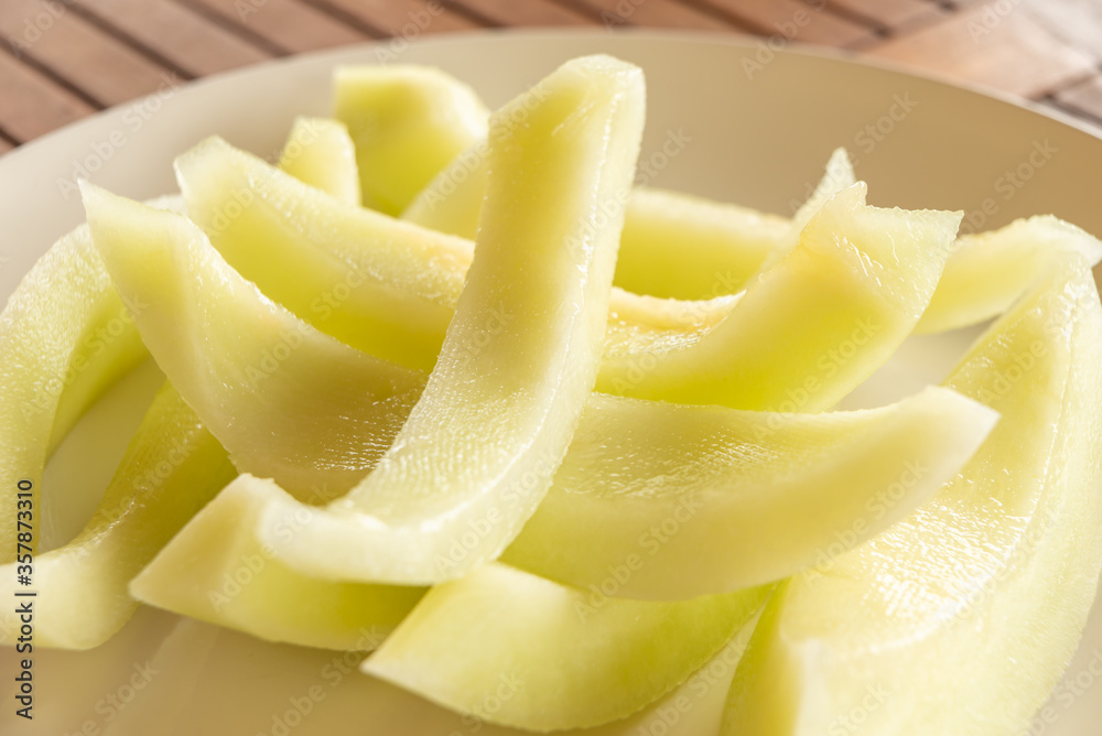 Sliced yellow melon on a white plate