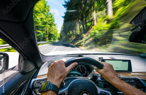 Obraz na plátne hands of car driver on steering wheel, road trip, driving on highway road
