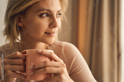 Quadro em tela Dreamy young woman with a hot beverage