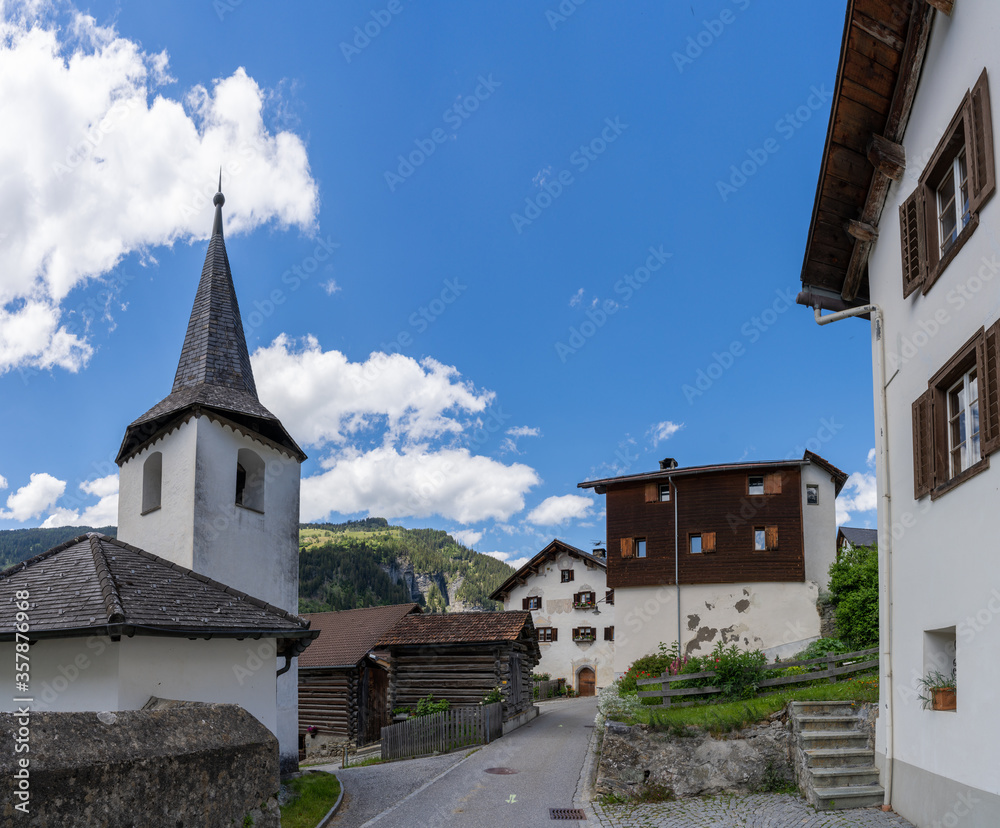 view of the historic village center of Reischen in the Val Schons in the Swiss Alps with a view of the  town church