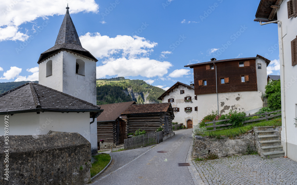 view of the historic village center of Reischen in the Val Schons in the Swiss Alps with a view of the  town church