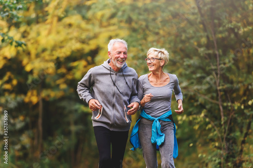 Smiling senior couple jogging in the park © lordn