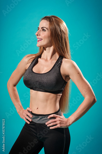 Skinny fitness blonde girl wearing sport clothes with her hand on her waist and looking to her right © Manuel