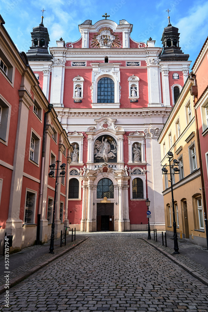 facade of the baroque church decorated with columns and statues in Poznan..
