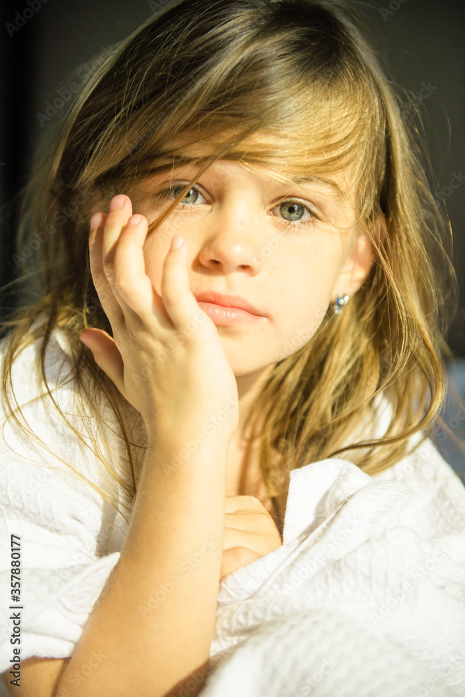 Portrait of a cute girl. A blonde girl looks at the camera. A very beautiful little girl in the sunlight Portrait of a cute girl. A blonde girl looks at the camera. A very beautiful little girl in the sunlight