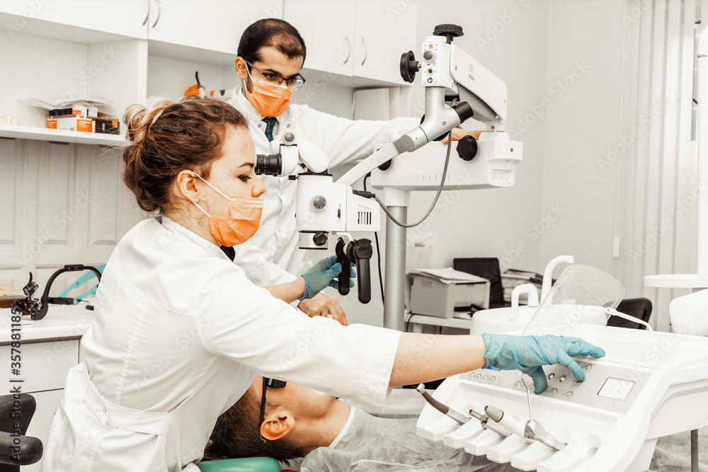 Two dentists treat a patient. Professional uniform and equipment of a dentist. Healthcare Equipping a doctor’s workplace. Dentistry Two dentists treat a patient. Professional uniform and equipment of a dentist. Healthcare Equipping a doctor’s workplace. Dentistry