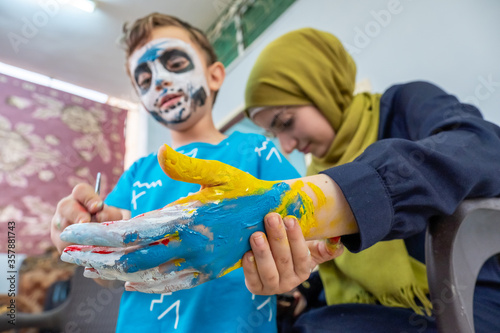 Boy drawing on his siter hand for halloween photo