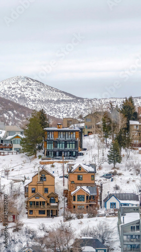 Vertical crop Park City Utah hill homes in winter with views of scenic snowy nature landscape