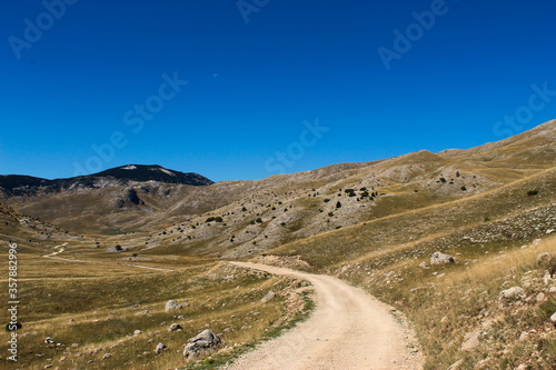 The mountain road and the rocky landscape of the Bjelasnica mountain. In the background, the top of the mountain mountain Bjelasnica.