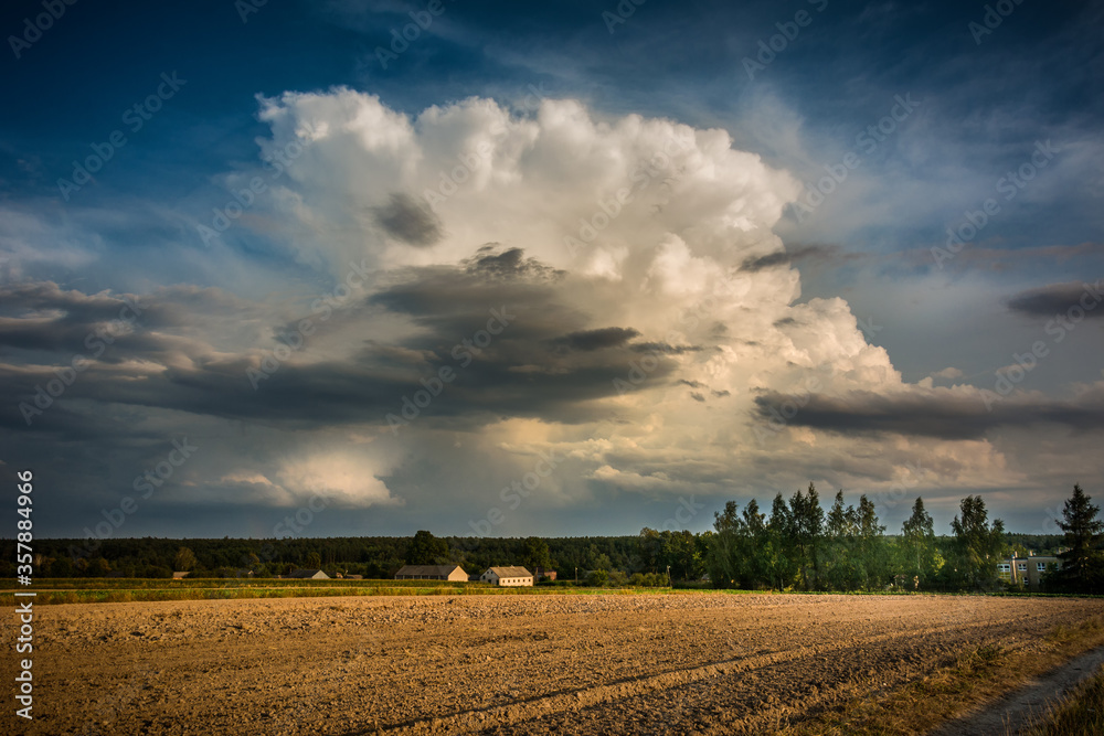Fototapeta premium storm clouds over the field and village