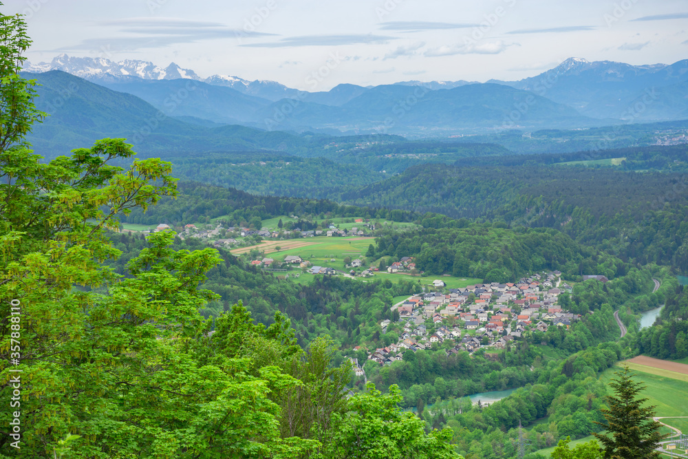 Slovenian countryside in spring with charming little village and Julian Alps in the background