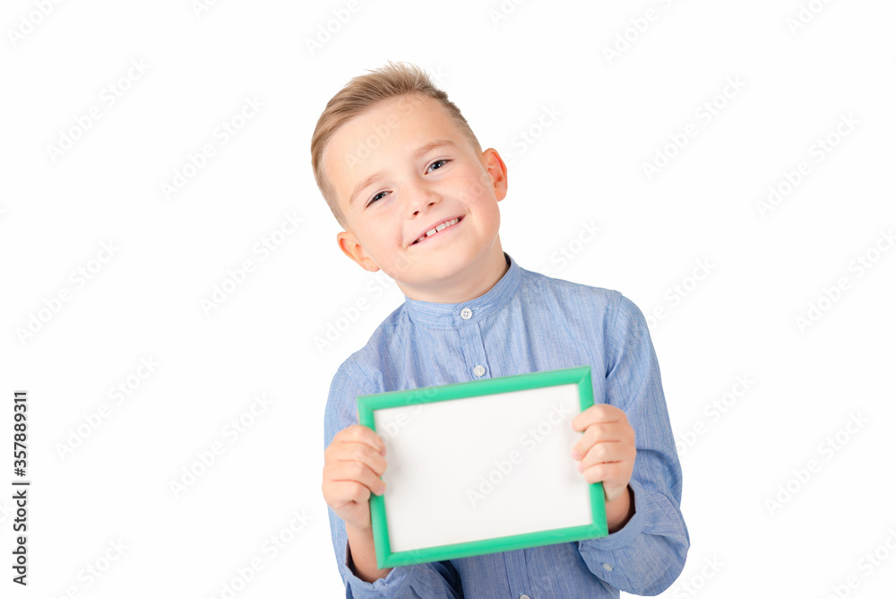 Cute smiling young caucasian schoolboy in shirt posing on white studio isolated background. Mock up copy space. Hold white empty blank billboard with place for text or image. Cute smiling young caucasian schoolboy in shirt posing on white studio isolated background. Mock up copy space. Hold white empty blank billboard with place for text or image.