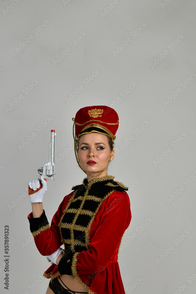 Fototapeta premium beautiful girl in an old hussar costume and in black boots and with a gun