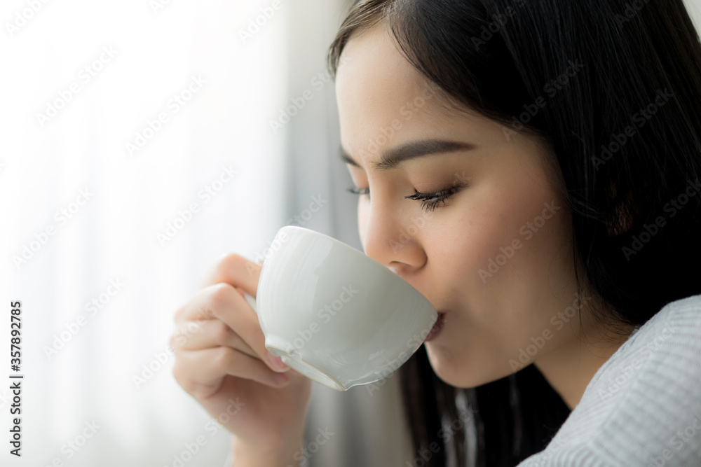 Close up young beautiful woman enjoy drinking with cup of coffee or tea near the window. Close up young beautiful woman enjoy drinking with cup of coffee or tea near the window.
