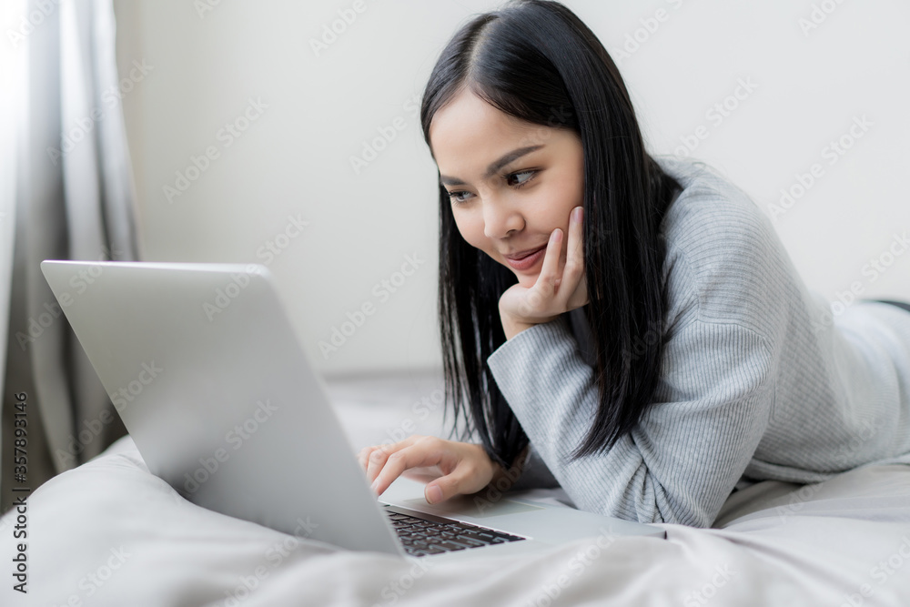 Young beautiful woman works from home with laptop computer at the the bedroom, living room.Communication and video conference concept Young beautiful woman works from home with laptop computer at the the bedroom, living room.Communication and video conference concept