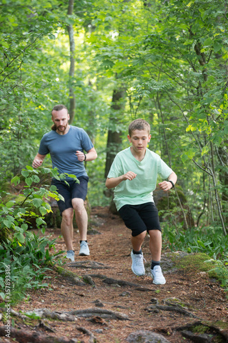 Fototapeta Naklejka Na Ścianę i Meble -  Father and son run in forest