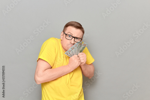 Portrait of funny greedy man holding money in hands photo