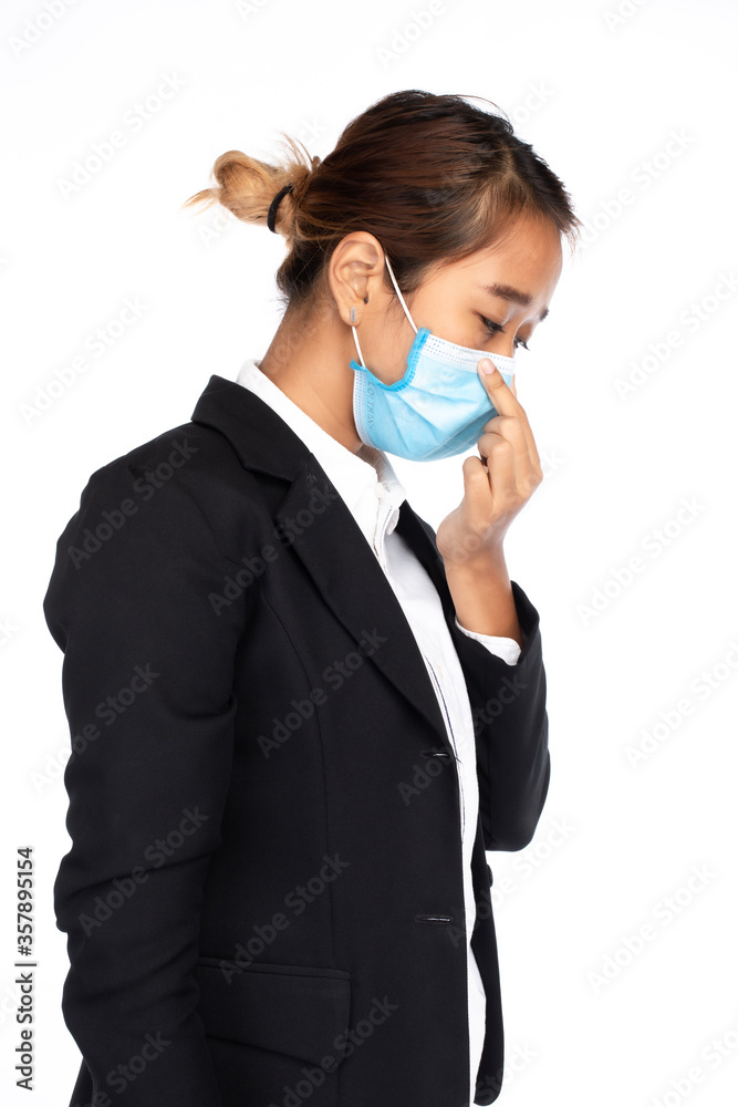 Side view of Asian businesswoman wearing surgical face mask in formal black suit jacket, touching face mask, studio lighting isolated on white background, coronavirus, COVID-19 concept Side view of Asian businesswoman wearing surgical face mask in formal black suit jacket, touching face mask, studio lighting isolated on white background, coronavirus, COVID-19 concept