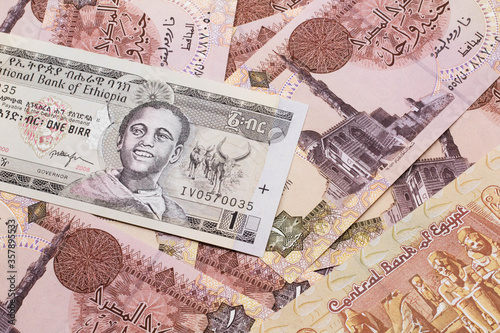 A close up image of a one Ethiopian birr bank note on a background of Egyptian one pound bank notes