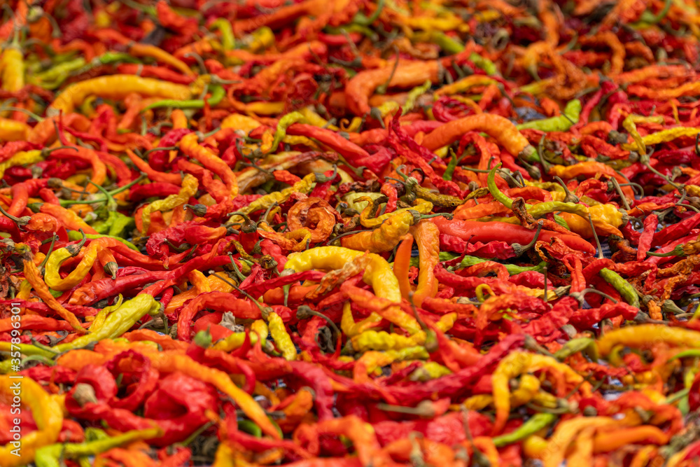 Red pepper vegetables stacked on a surface as background.
