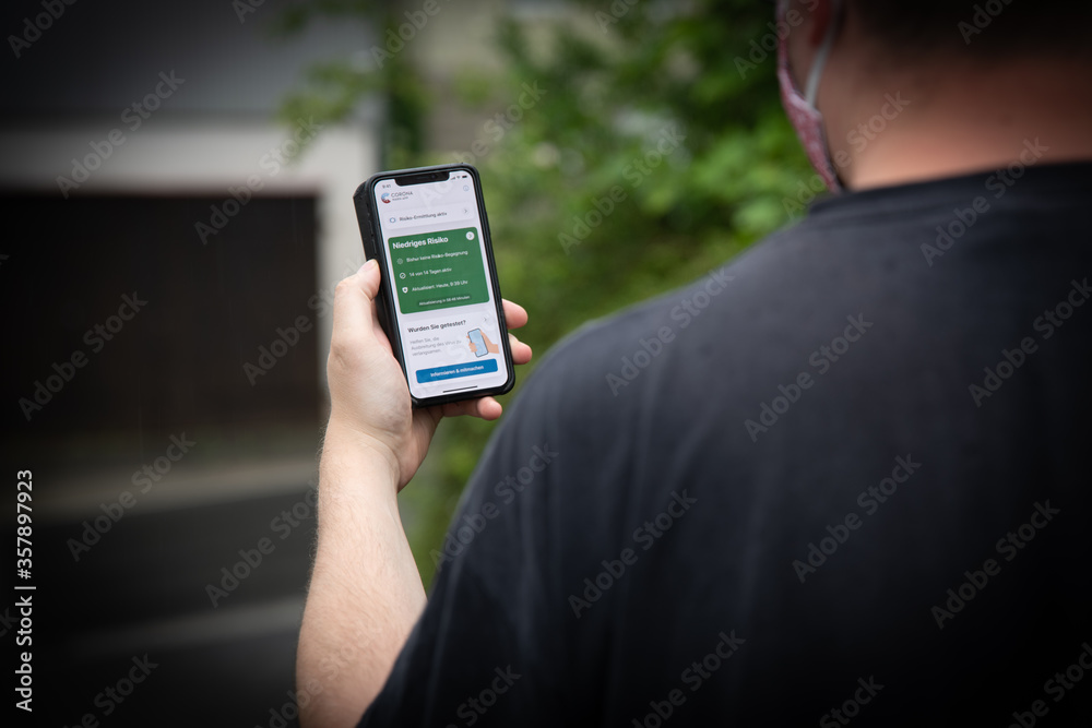 User mit der offiziellen Corona-Warn-App auf dem iPhone User mit der offiziellen Corona-Warn-App auf dem iPhone