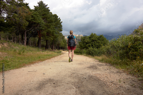 Woman with a backpack walking alone in the mountain, hiking. Concept of freedom