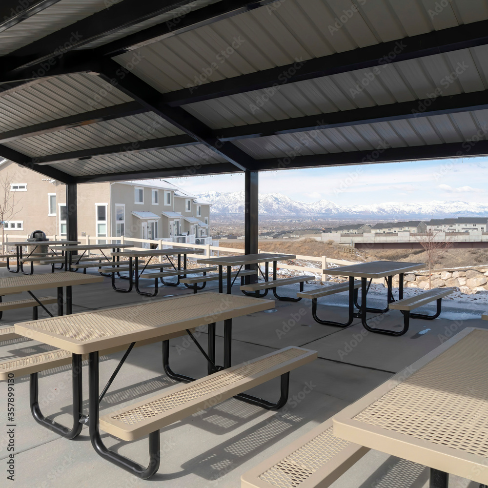 Fototapeta premium Square crop Pavilion at a park in South Jordan City Utah overlooking snowy Wasatch Mountains